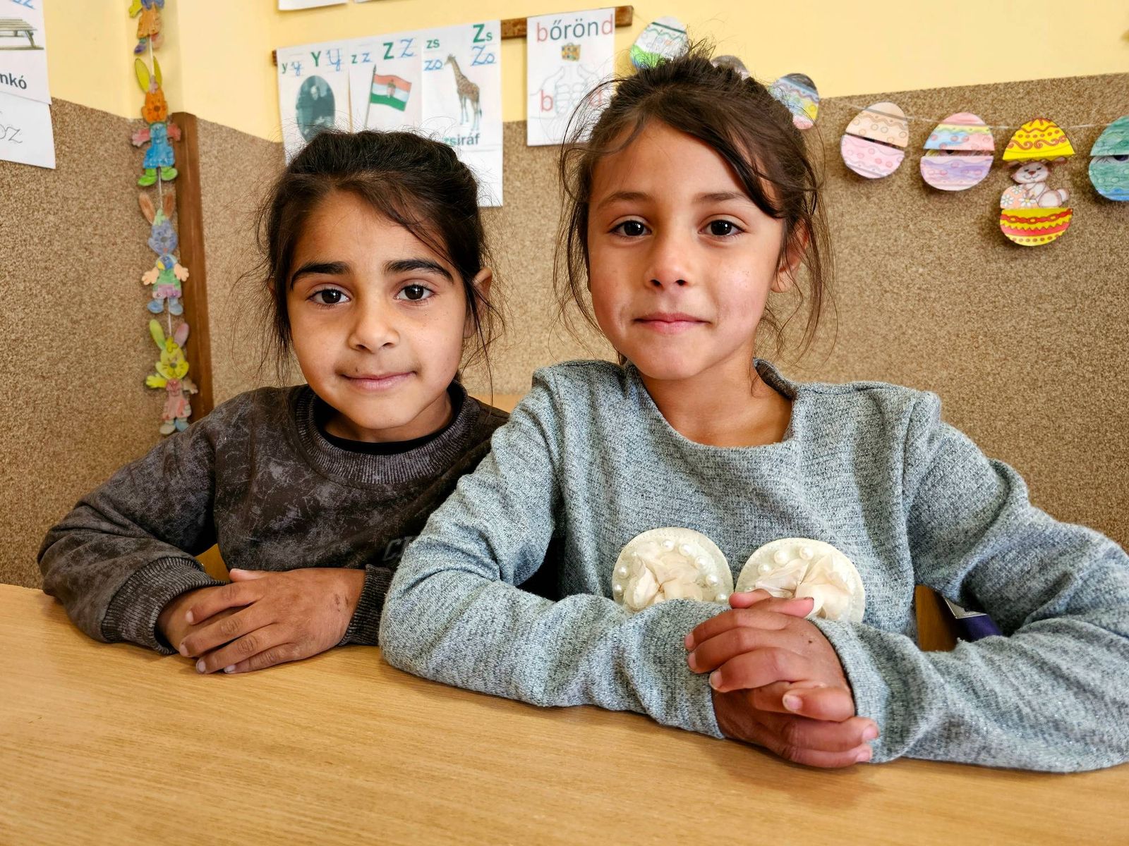 Twee meisjes aan een schooltafel in de klas