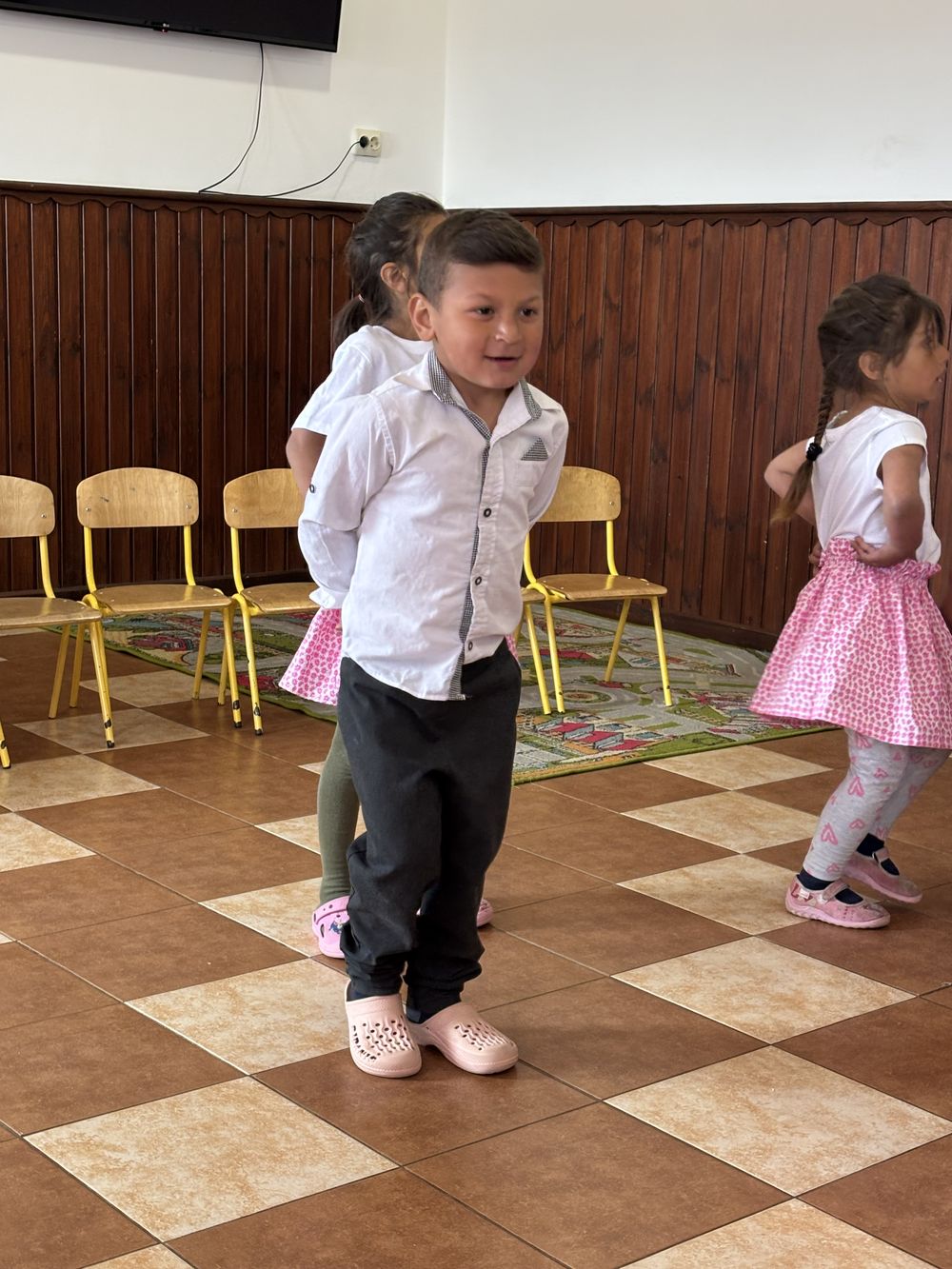 Een jongetje danst mee op de kleuterschool